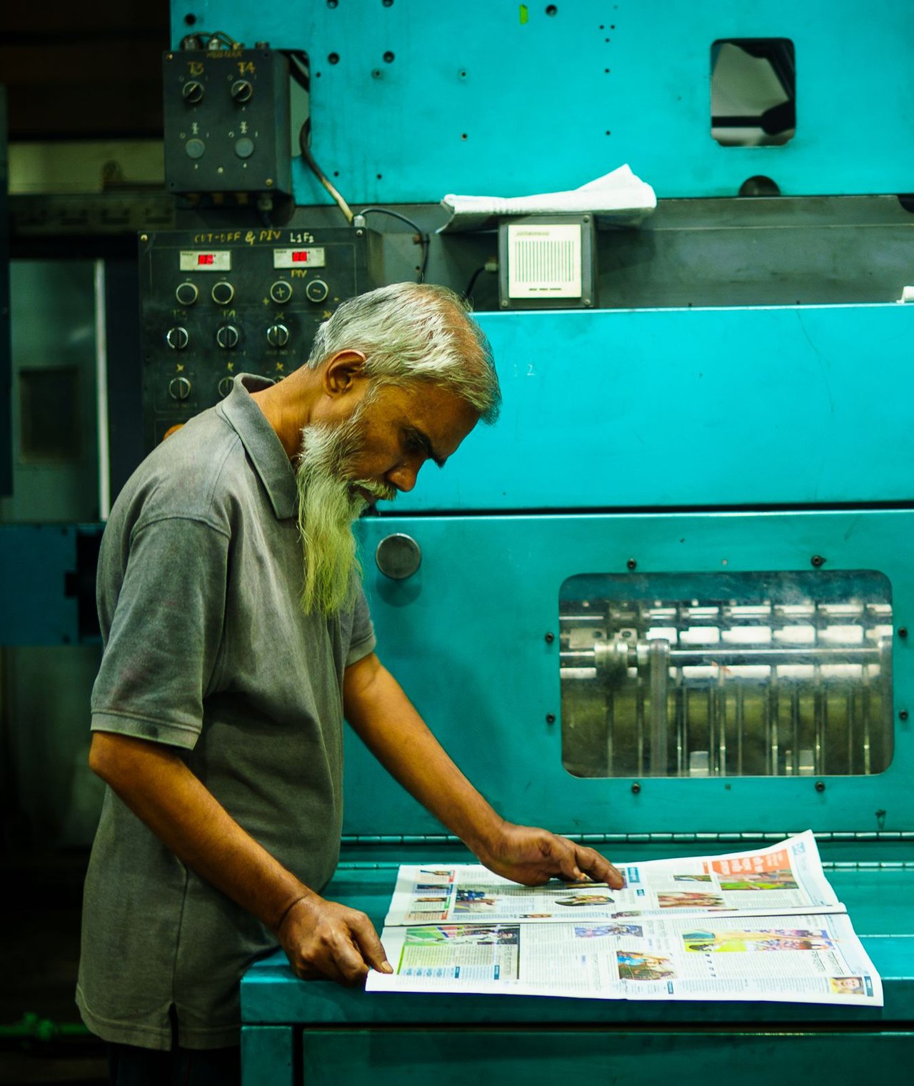 A pressman checking a fresh print at the press